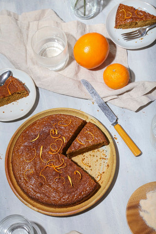 orange olive oil cake on surface with knife