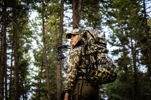 woman bowhunter in the woods during early season deer hunting