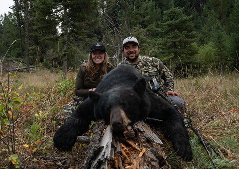 man and woman with bear after hunting