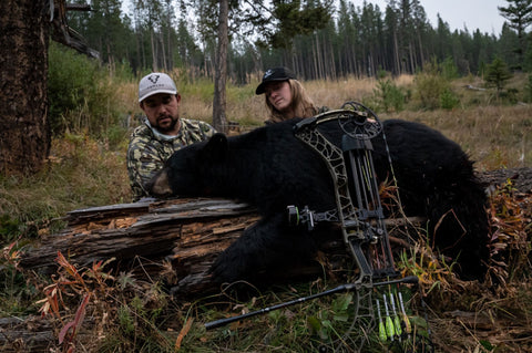 two bow hunters with a bear