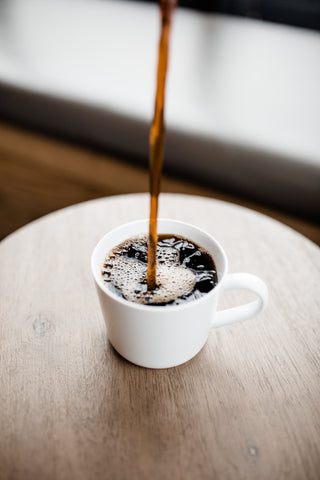 Brewed coffee pouring into a cup
