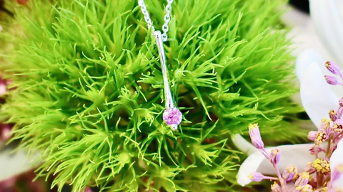 Pendant in 10kt white gold, set with a 4mm pink Tourmaline placed on green foliage