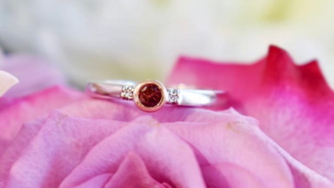 Bague pour femme en or 10kt blanc et rose, serti d'une Tourmaline rose et de deux diamants de 1pts chaques posée sur une fleur rose