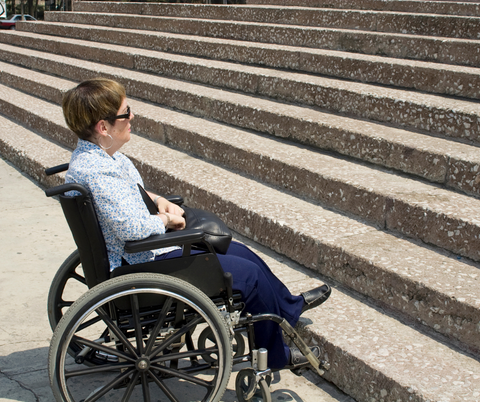 Women in wheelchair looking up the stairs 