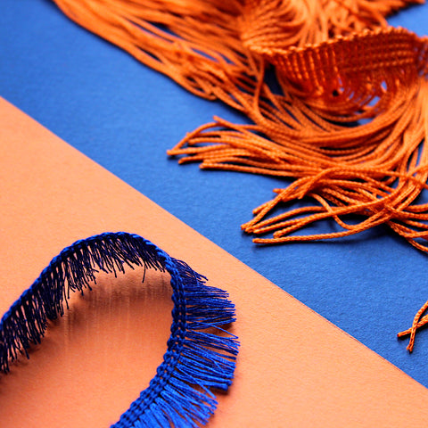 Orange and Blue fringes are placed freely on contrasting coloured backgrounds