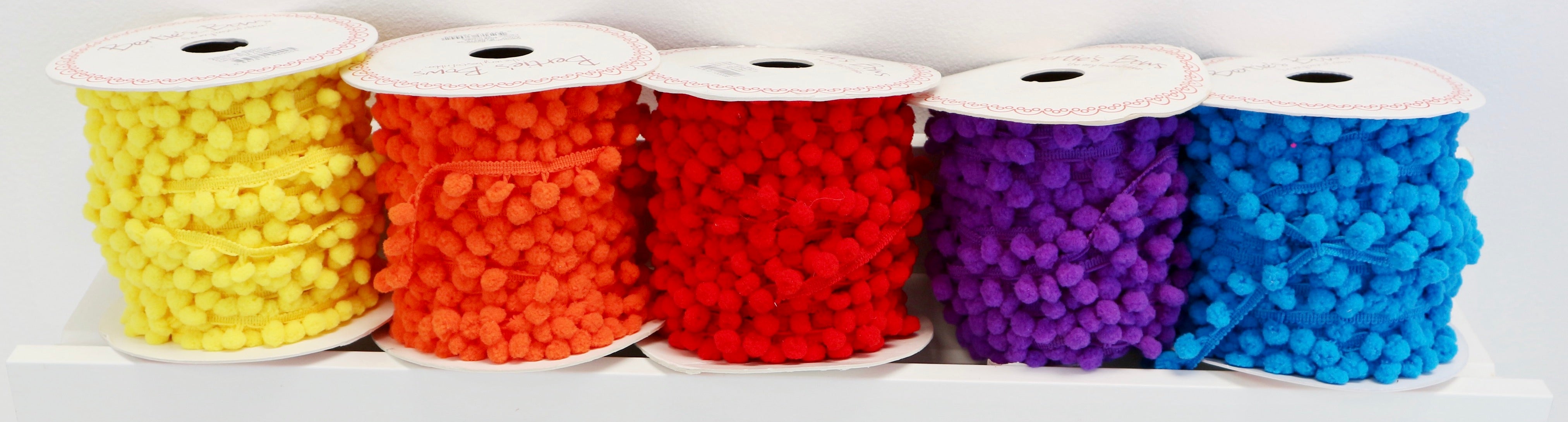 rainbow display of Pom Pom Trim in rainbow colours