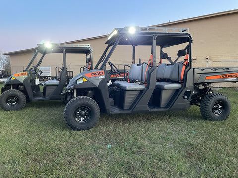 Two Polaris Pro side-by-side vehicles positioned next to each other