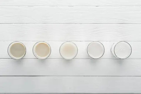 Different milk variations on white wooden counter