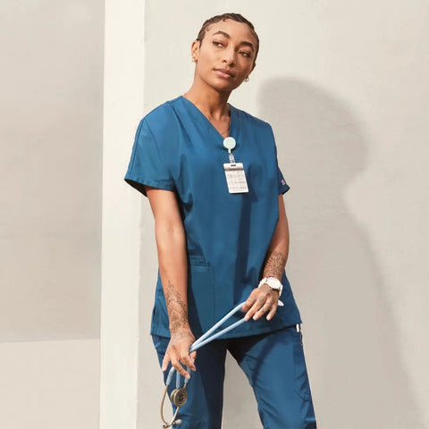 Nurse wearing classic fit scrubs in caribbean blue.
