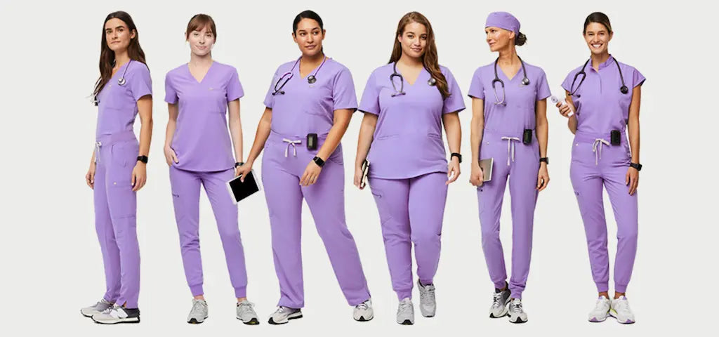 A group of female pediatric nurses wearing lilac colored scrub uniforms on a white background.
