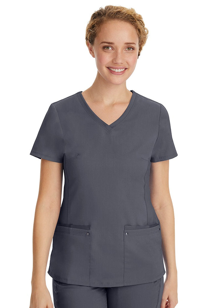 A young LPN wearing a Purple Label Women's Juliet Yoga Scrub Top in Pewter  featuring 2 front patch pockets.