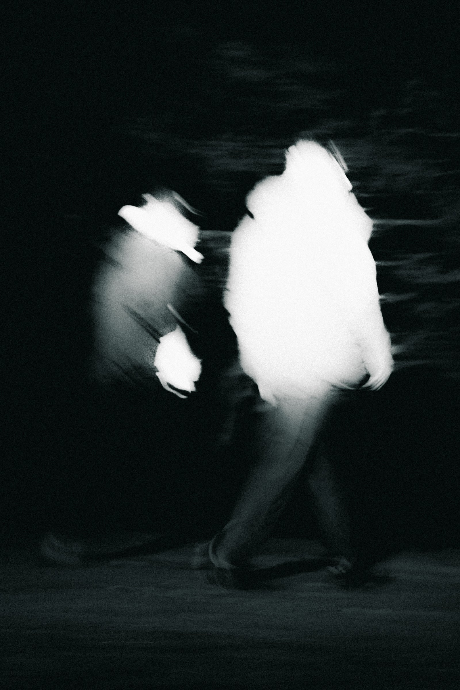 Two hikers, photographed at night whilst hiking in head torches.