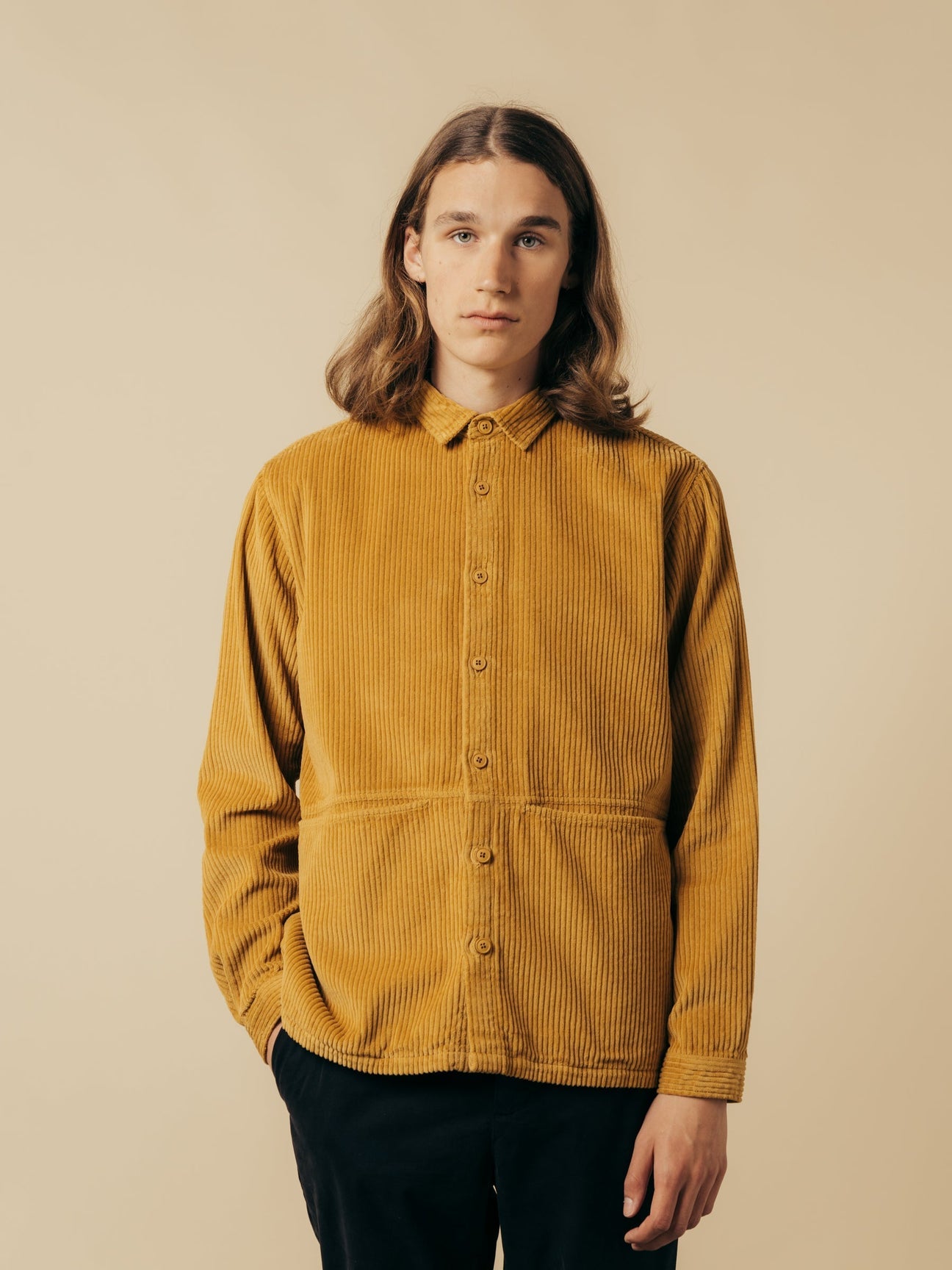 A man wearing a light brown corduroy overshirt.