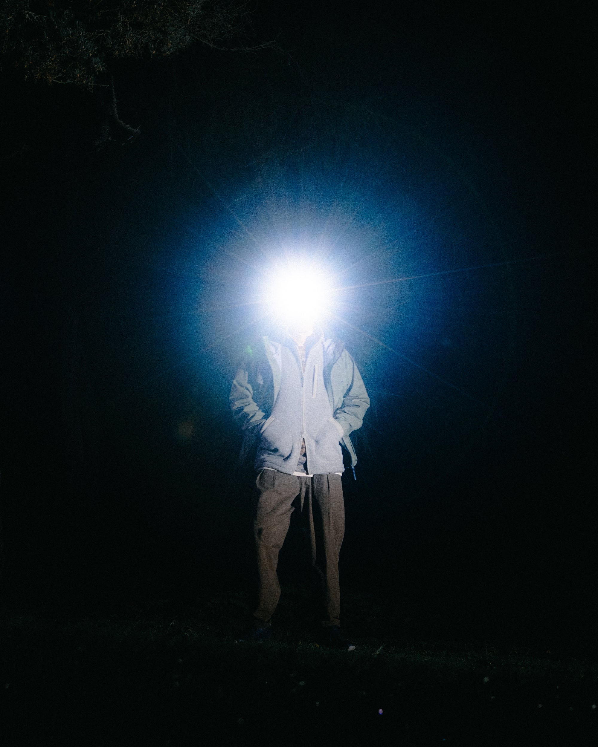 A man wearing a head torch whilst hiking in the Cairngorms after dark.