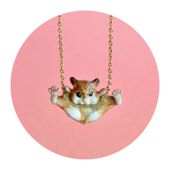 Porcelain Hamster Necklace on a pink background