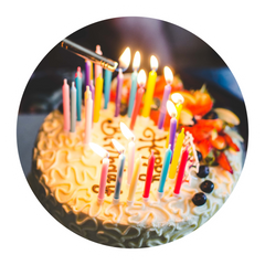 A happy birthday cake with lots of colored candles