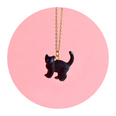 Black cat porcelain necklace with a pastel pink background
