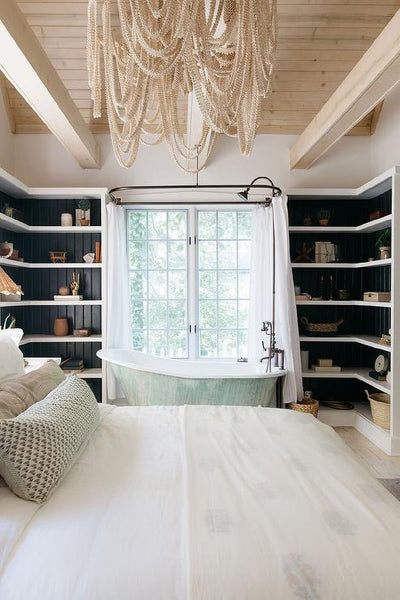 Vintage cast iron bath in bedroom by window