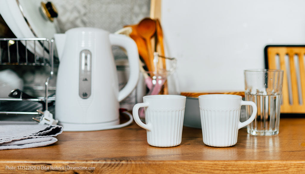 Kettle and mugs on a counter.