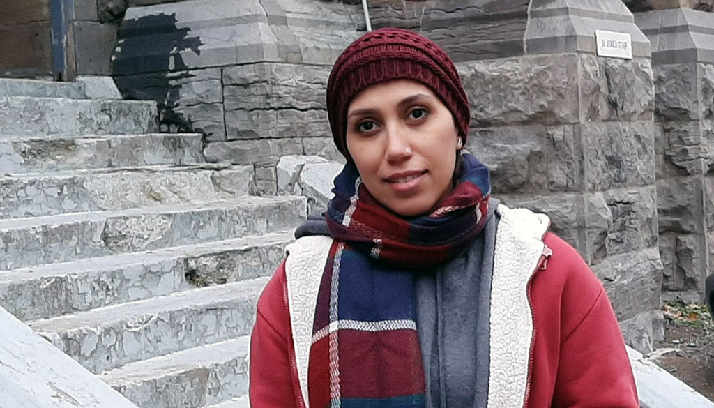 A woman standing in front of some stairs.