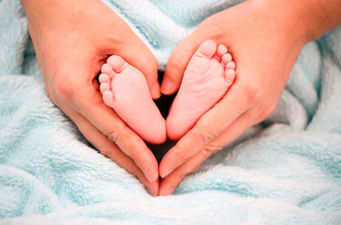 Hands wrapped around baby feet