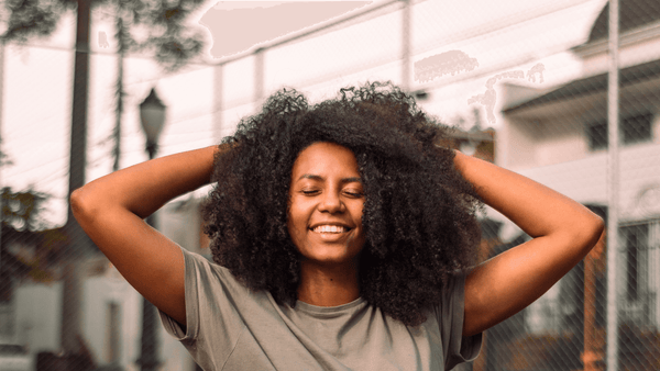 American african woman happy and touching her beautiful curly hair