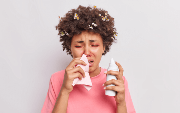 a black woman suffering from allergic reaction blowing her nose