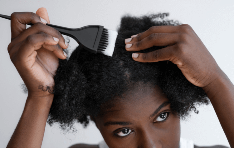 American African girl high arranging hair applyin gel on a curly hair