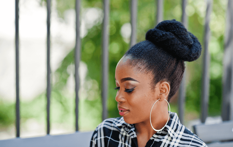 an african woman smiling with bun hairstyle