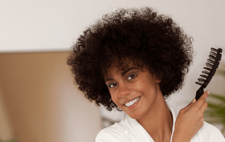 Front view smiley afro african woman holding comb