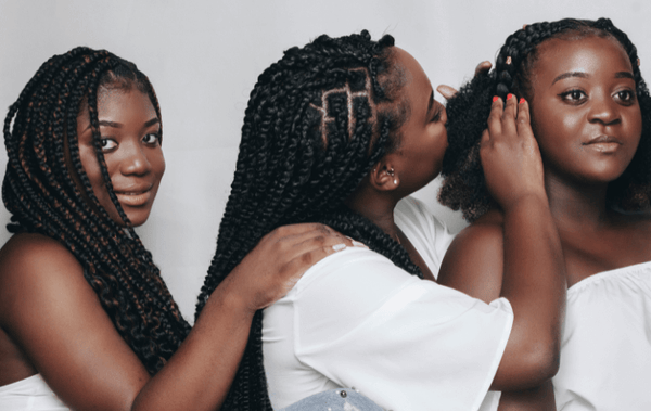 3 women with dreadlocks checking each others hair