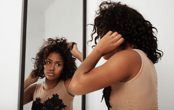 a black woman checking her hair for receding hairline