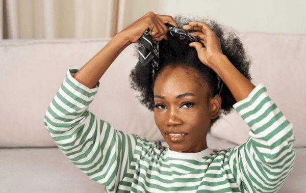 a black woman brushing her hair with receding hairline