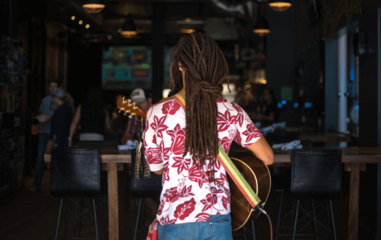 back view africa american woman with beautiful dreaded hair playing guitar