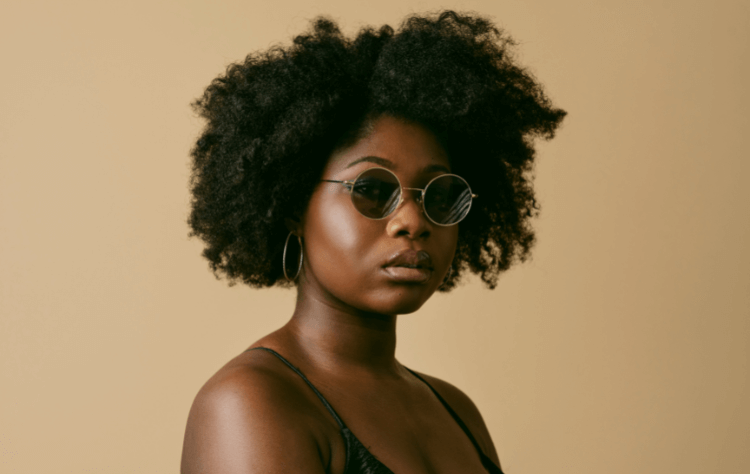 black woman afro posing with sunglasses side view