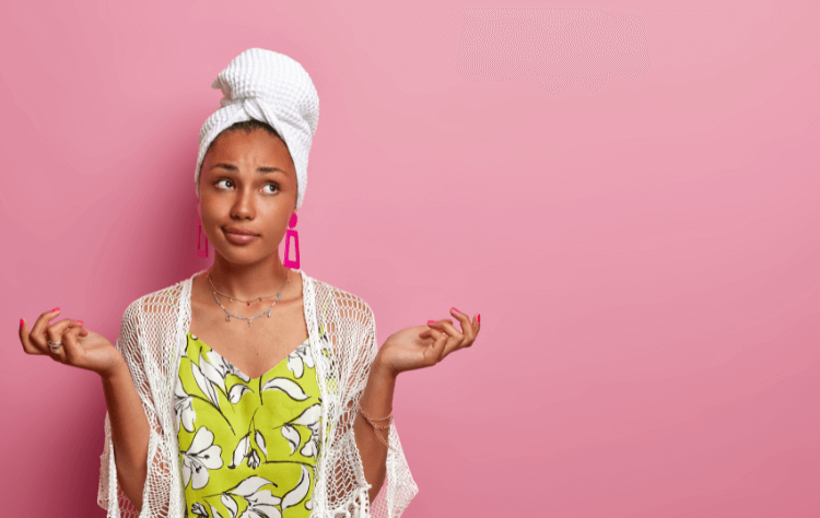 black woman spreads hands sideways, feels hesitant, cannot decide what to wear