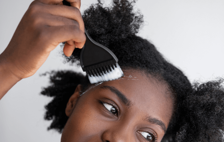 front view young curly black woman using hair product