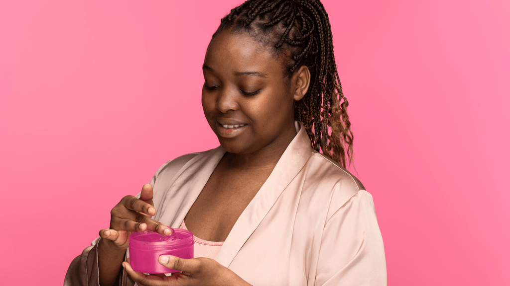 side view black curly woman holding moisturizing cream container
