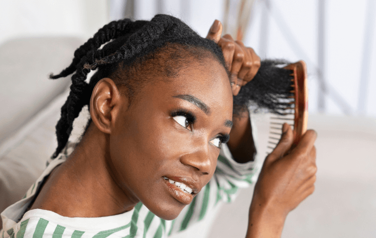 side view black smiley woman combing braided hair