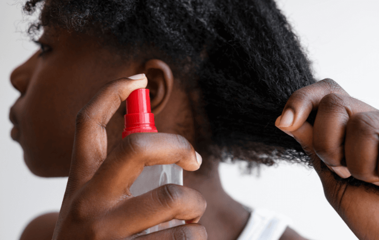 side view you black woman using hair product on a curly hair