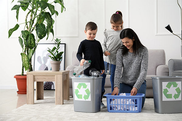 Young family recycling single-use plastic bottles.