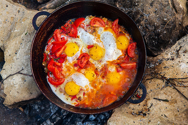 A closeup of food cooked on an outdoor camping stove.