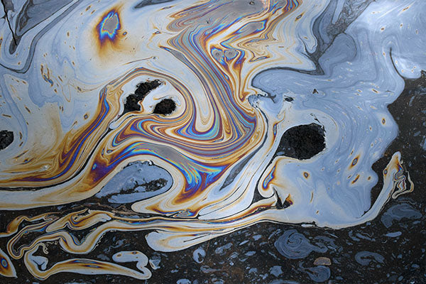Colorful, swirling image of an oil spill on water.