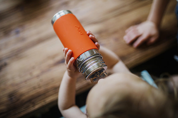 Pura Stainless baby bottle being used by a young infant.