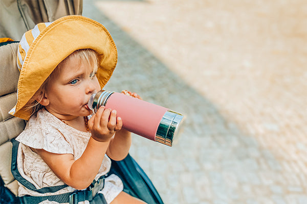 Young, blonde toddler drinking from a sustainable Pura Stainless bottle.