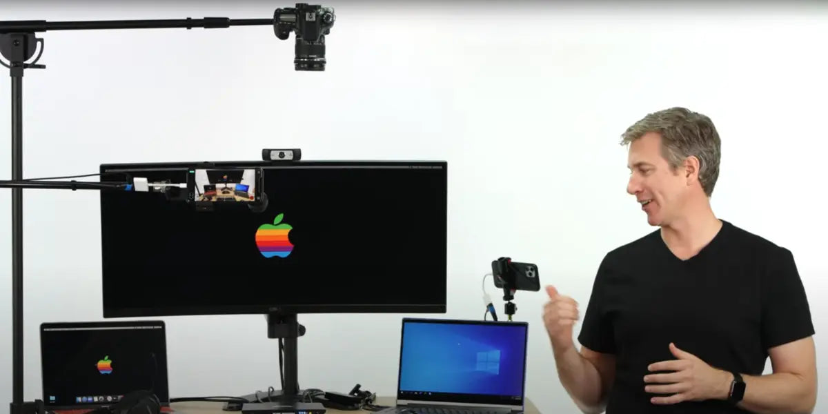 Avico Justin demonstrating how to connect 2 computers to 1 monitor using a KVM switch with MacBook, Windows laptop, and external monitor.