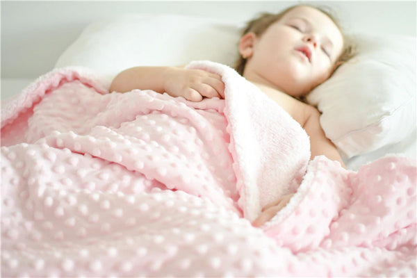 enfant dort avec une couverture Minky rose Lenappy sur lui