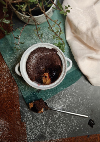 Peanut Butter and Jam Chocolate Lava Cakes with a spoon and a spoonful on it next to the mug