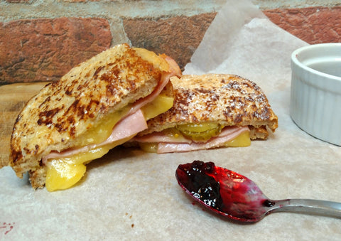 two air fryer monte cristos stacked with a spoon of jam next to it