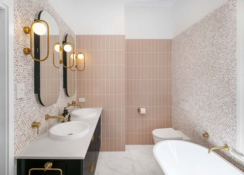Pink tiled bathroom with about space wall lights and bath